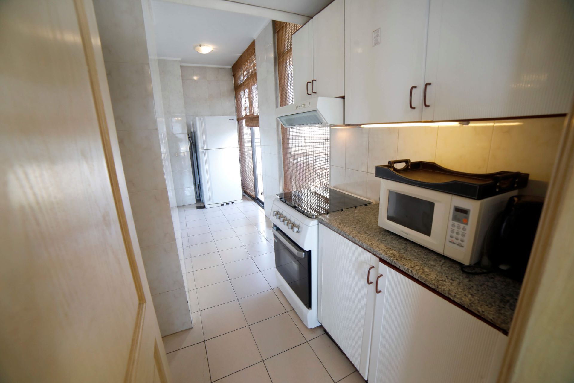 A kitchen with white cabinets and a microwave
