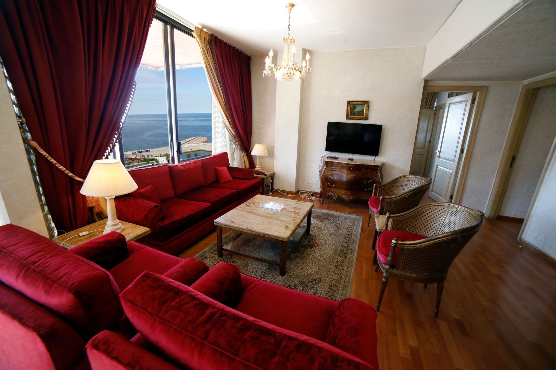 A living room with red furniture and a flat screen tv