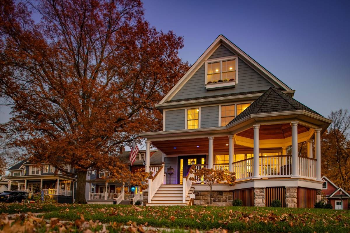A home with a clear sky and an Autumn-colored tree at John Paul's Paint & Decor near Bourbonnais, Illinois