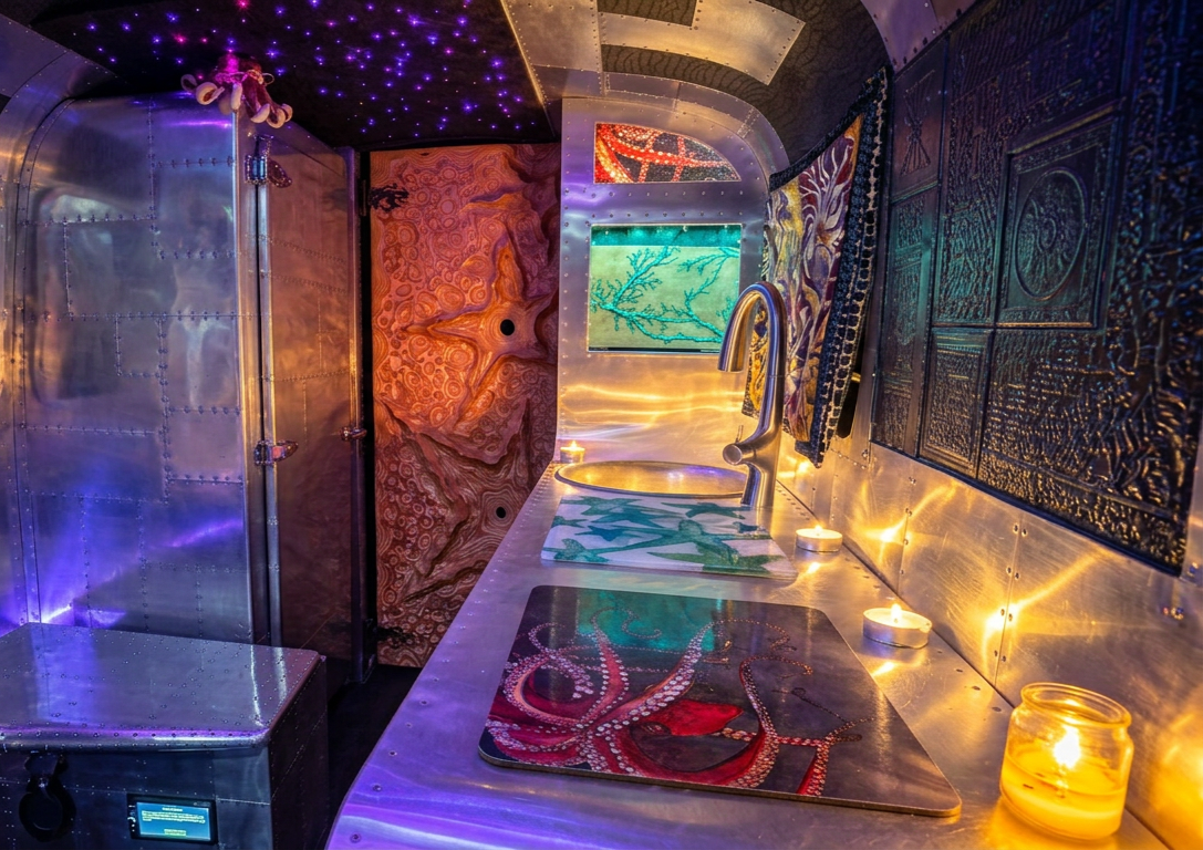 Colorful spa hallway with glowing candles, purple lights, and patterned walls leading to a turquoise pool