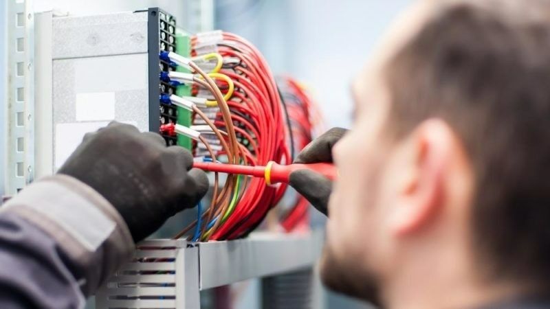 A Electrician With Black Gloves Uses a Screwdriver — McGrath Electrical & Data in South Grafton, NSW
