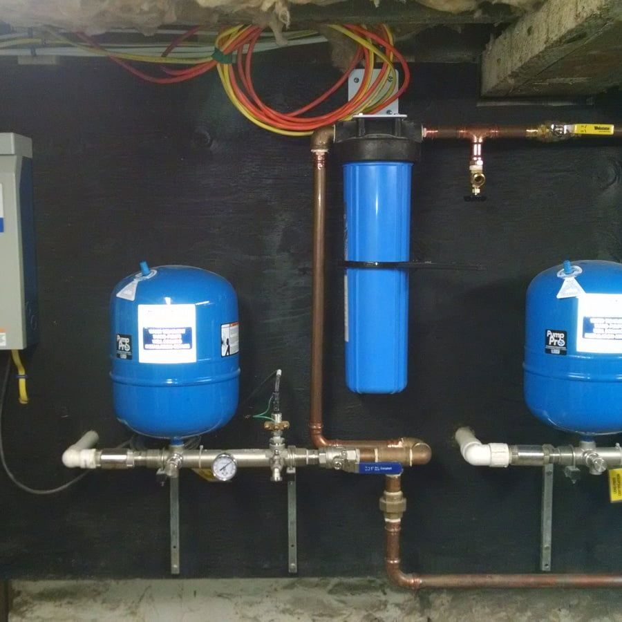 Two blue water tanks are connected to copper pipes