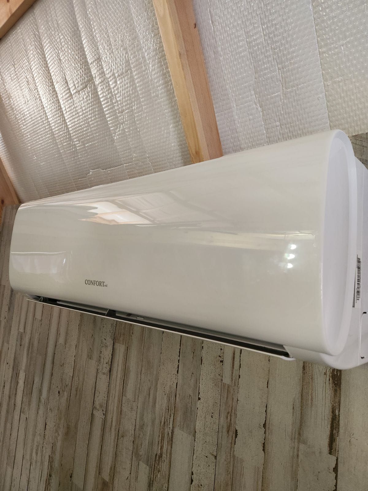 White wall-mounted air conditioner indoors against insulated wall panels