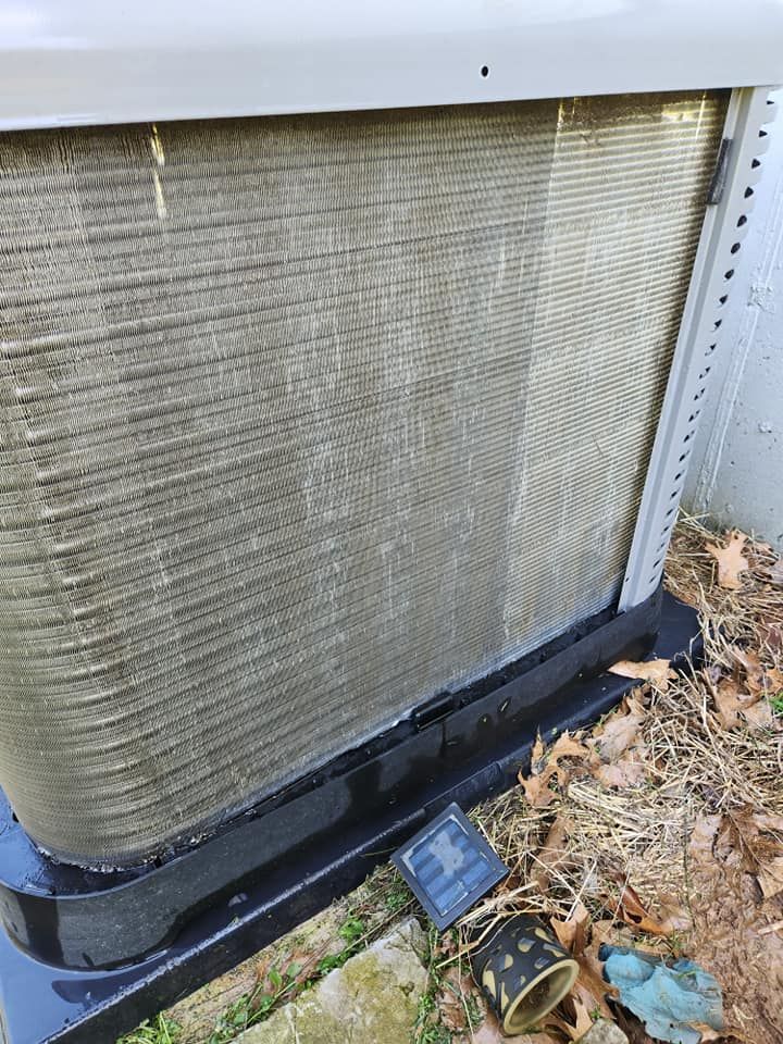 Outdoor HVAC unit with dirty coil and debris around the base
