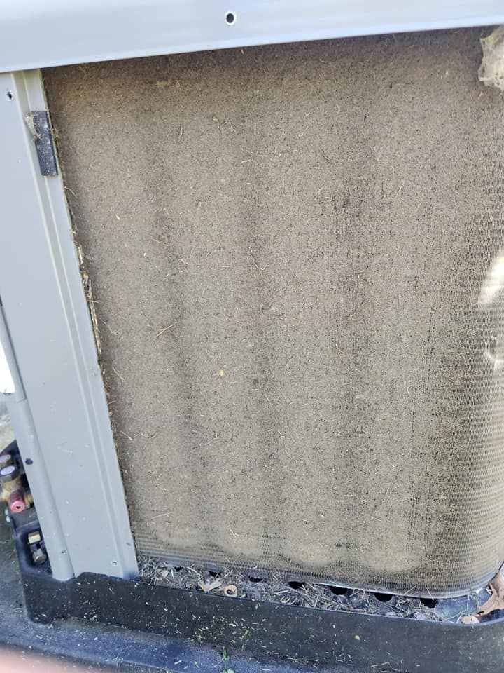 Damaged beige wall panel with peeling bottom edge and debris on a floor inside a building