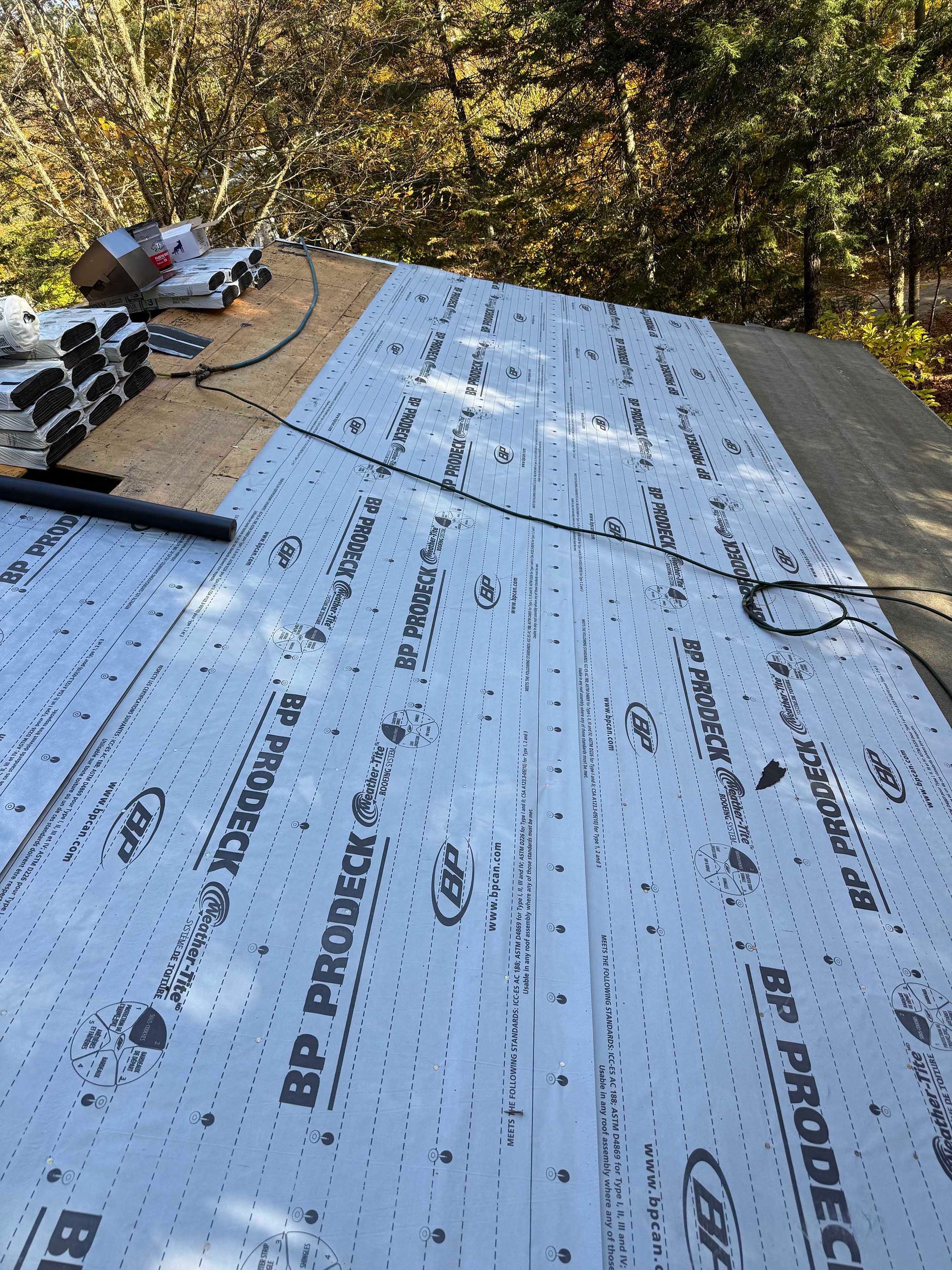 Toiture en construction, composée de panneaux de bois partiellement recouverts d'une sous-couche synthétique BP Prodeck.