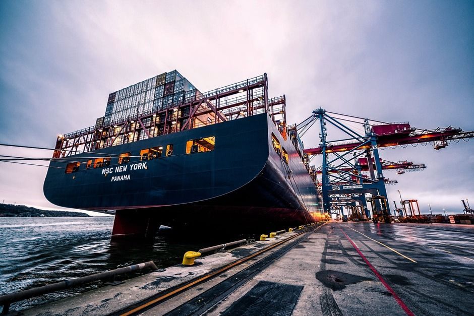 Shipping vessel delivering shipping containers to port.