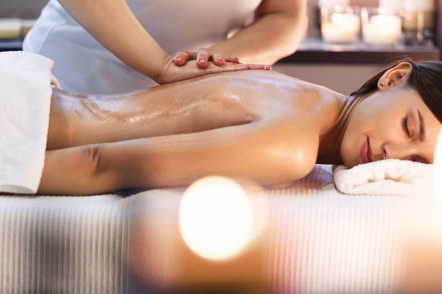 Spa massage with a woman lying face down while a therapist massages her back