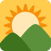 Sunrise over green mountains and hills under a clear sky