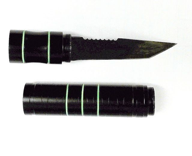 Black pen knife with the blade extended, shown above its closed cylindrical handle.