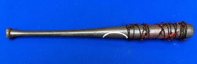 A silver metal baton or wand wrapped with red wire on a blue background