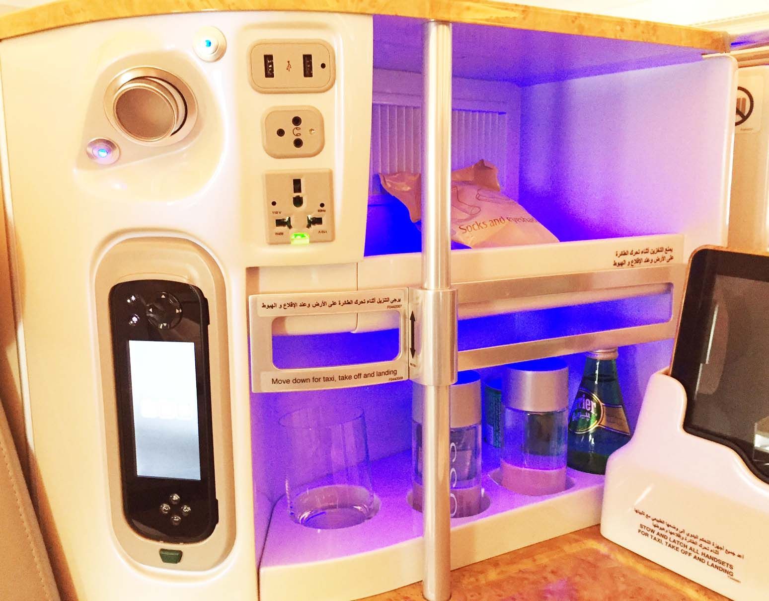 Compact miniature dollhouse kitchen with purple-lit shelves, cabinets, and tiny appliances