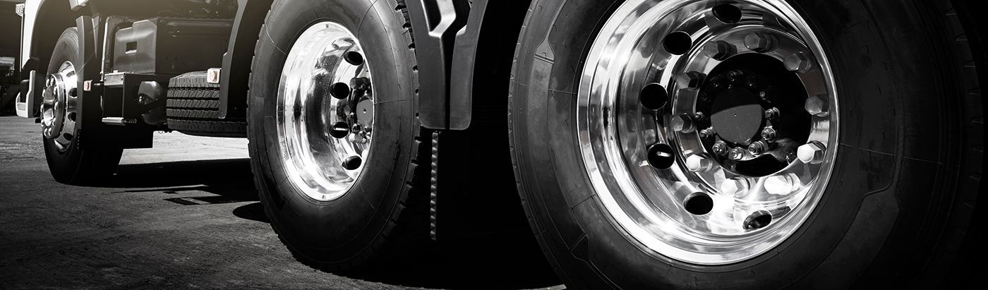 Truck tires on a dark road, close-up with a black and white effect.