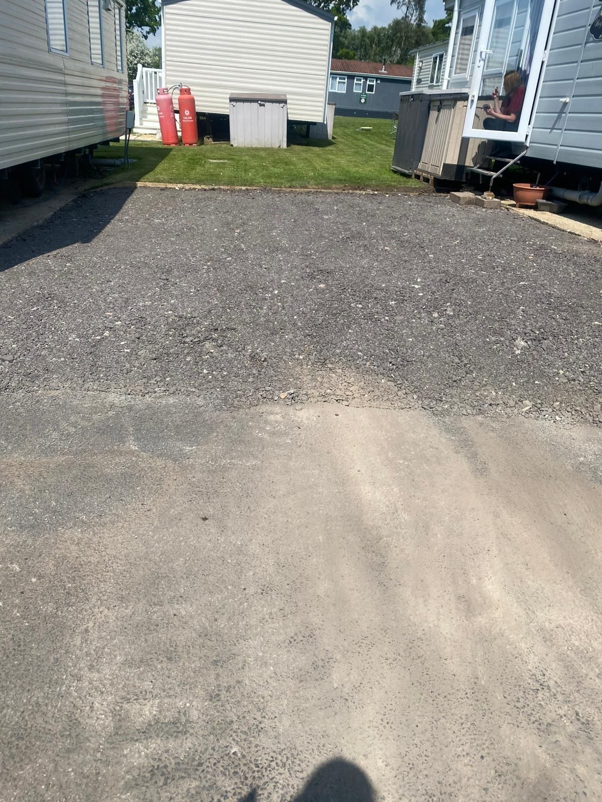 Gravel parking area between mobile homes.
