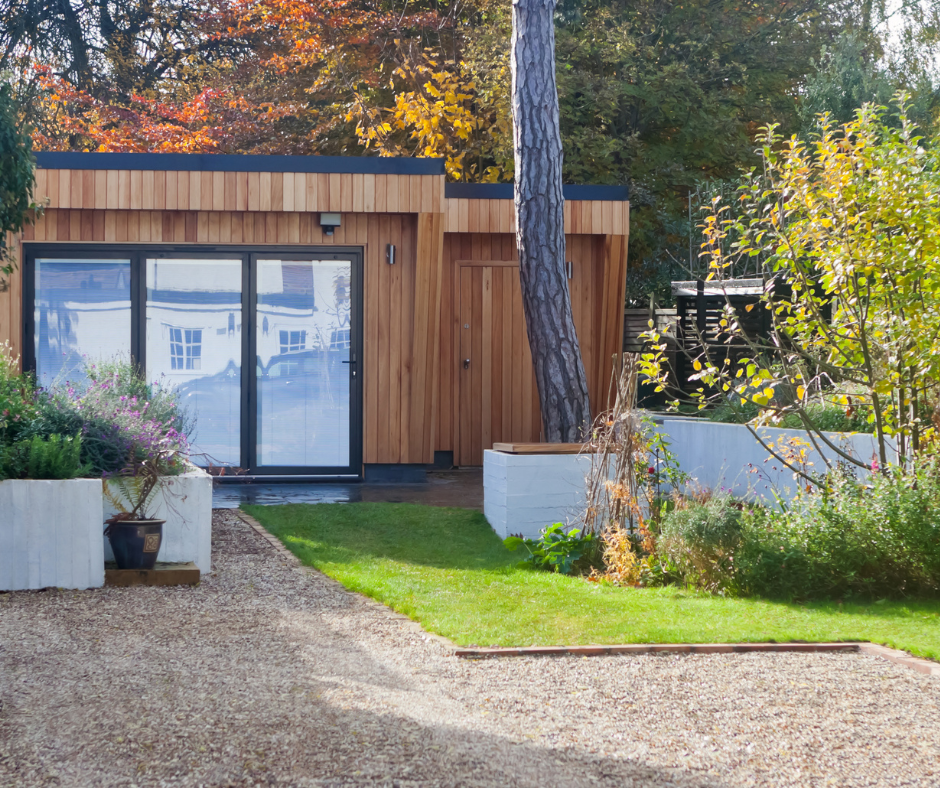 A small wooden house with a driveway leading to it