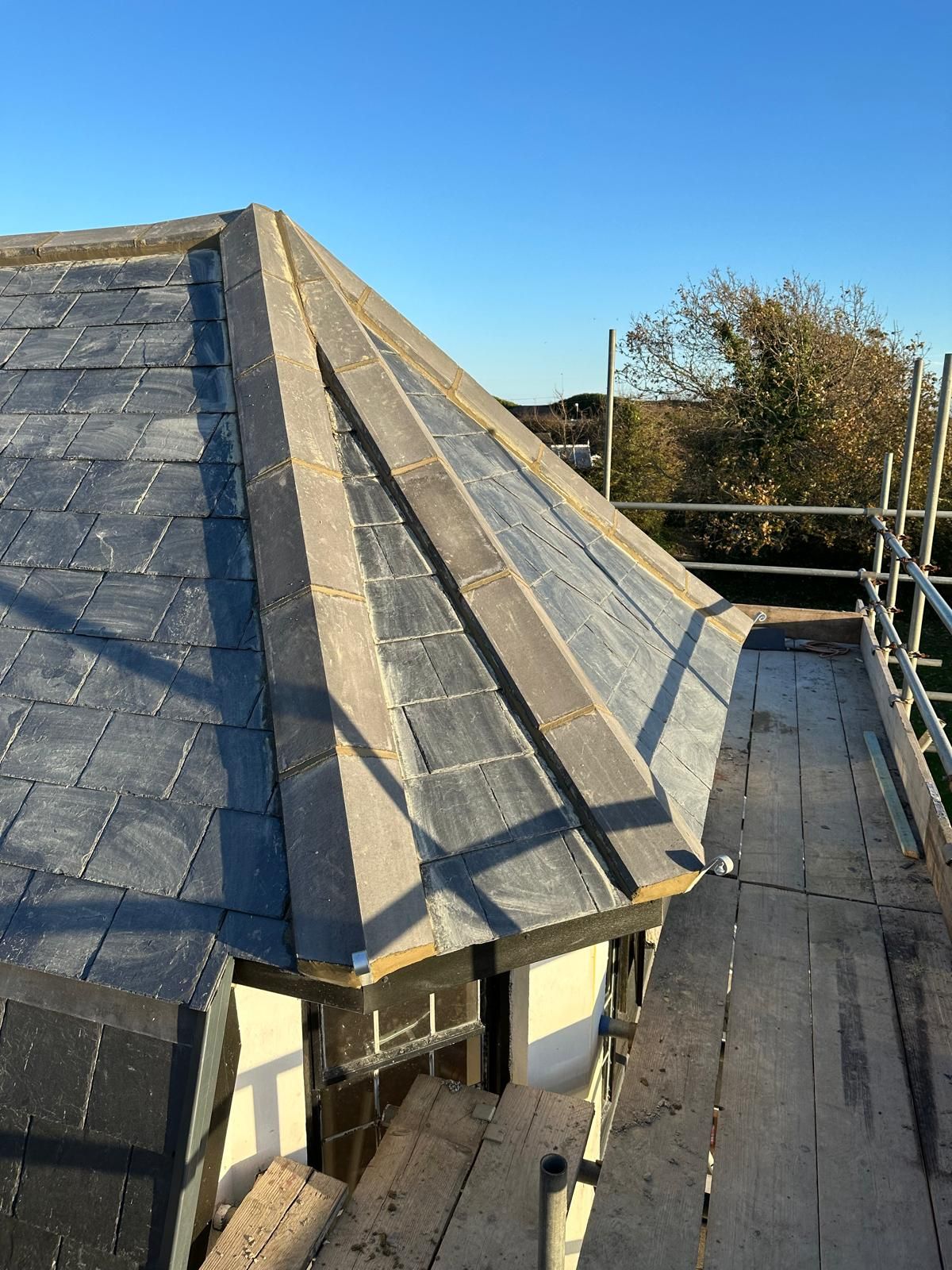 A roof is being built on top of a building with scaffolding.