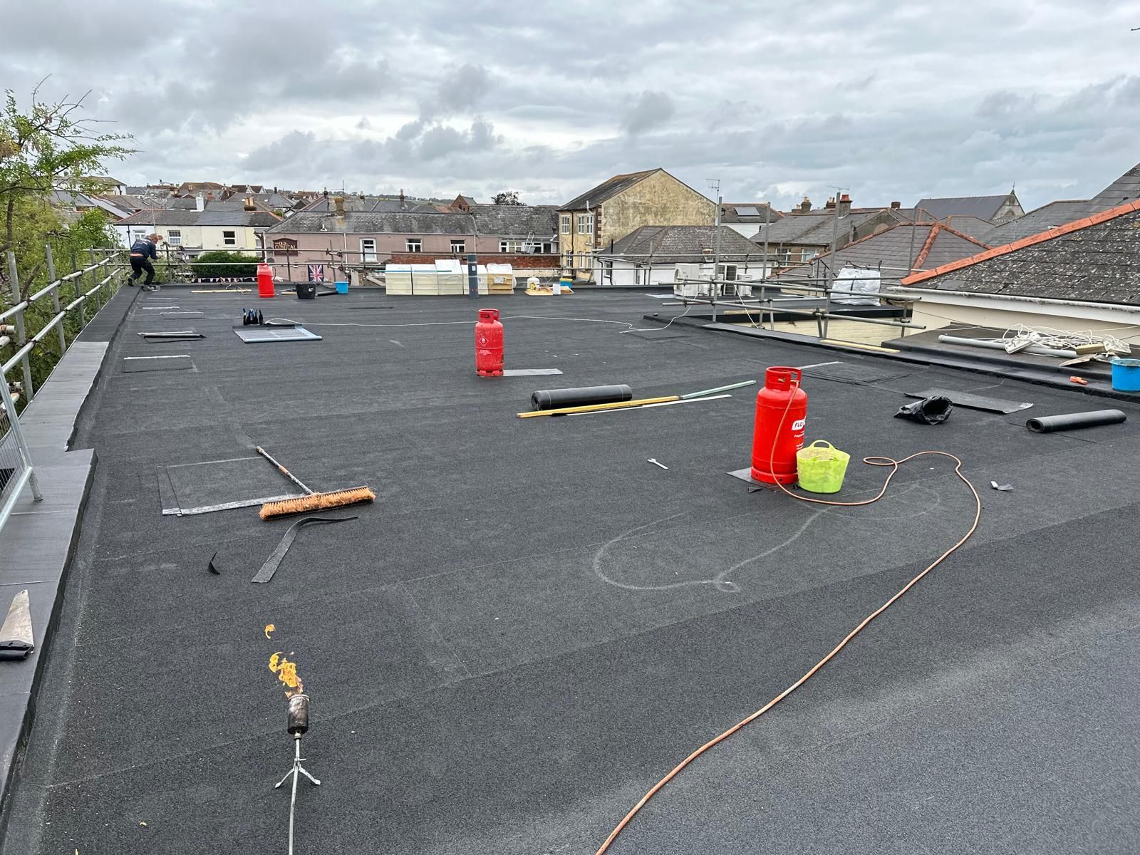 A roof with a lot of objects on it and a lot of buildings in the background.