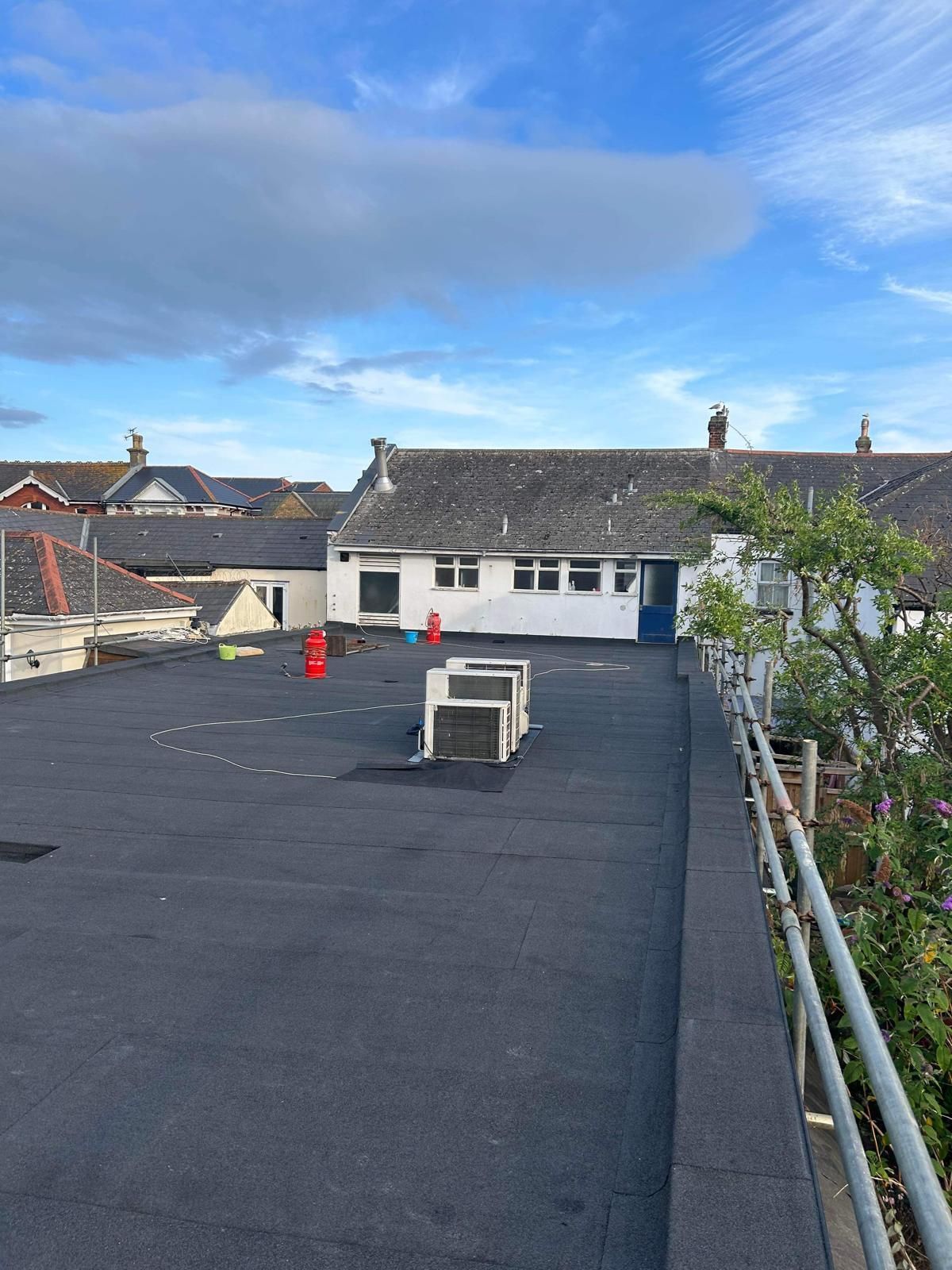 The roof of a building with a black roof and a blue sky in the background.