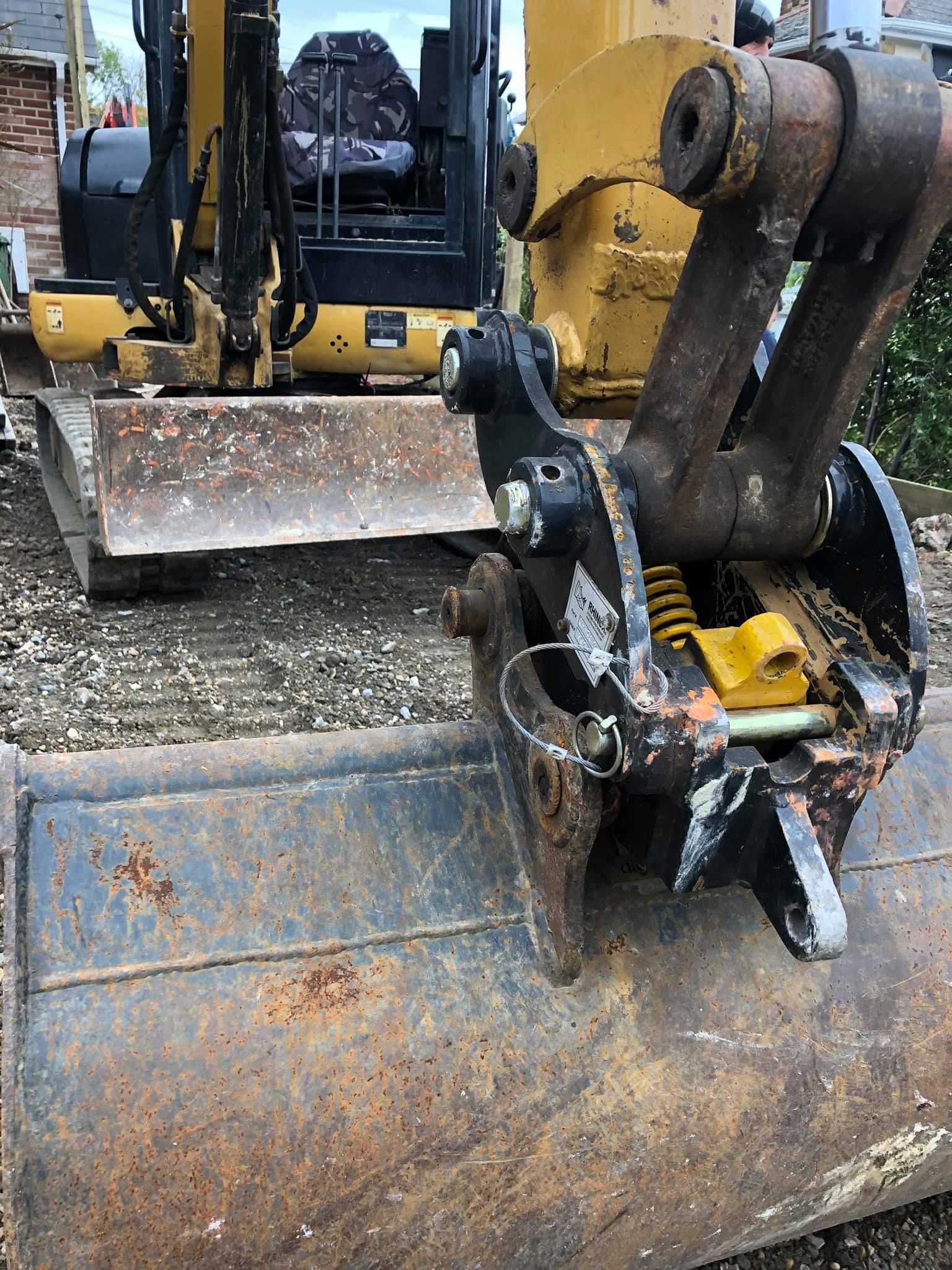 A yellow and black excavator is parked on a gravel road.