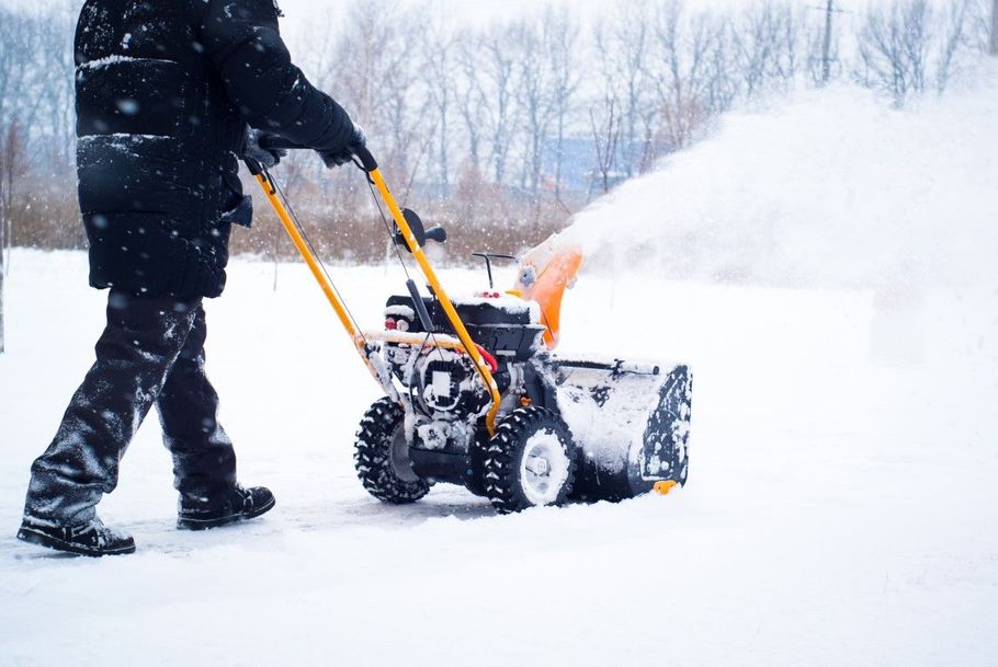 White pickup truck plowing snow in driveway.