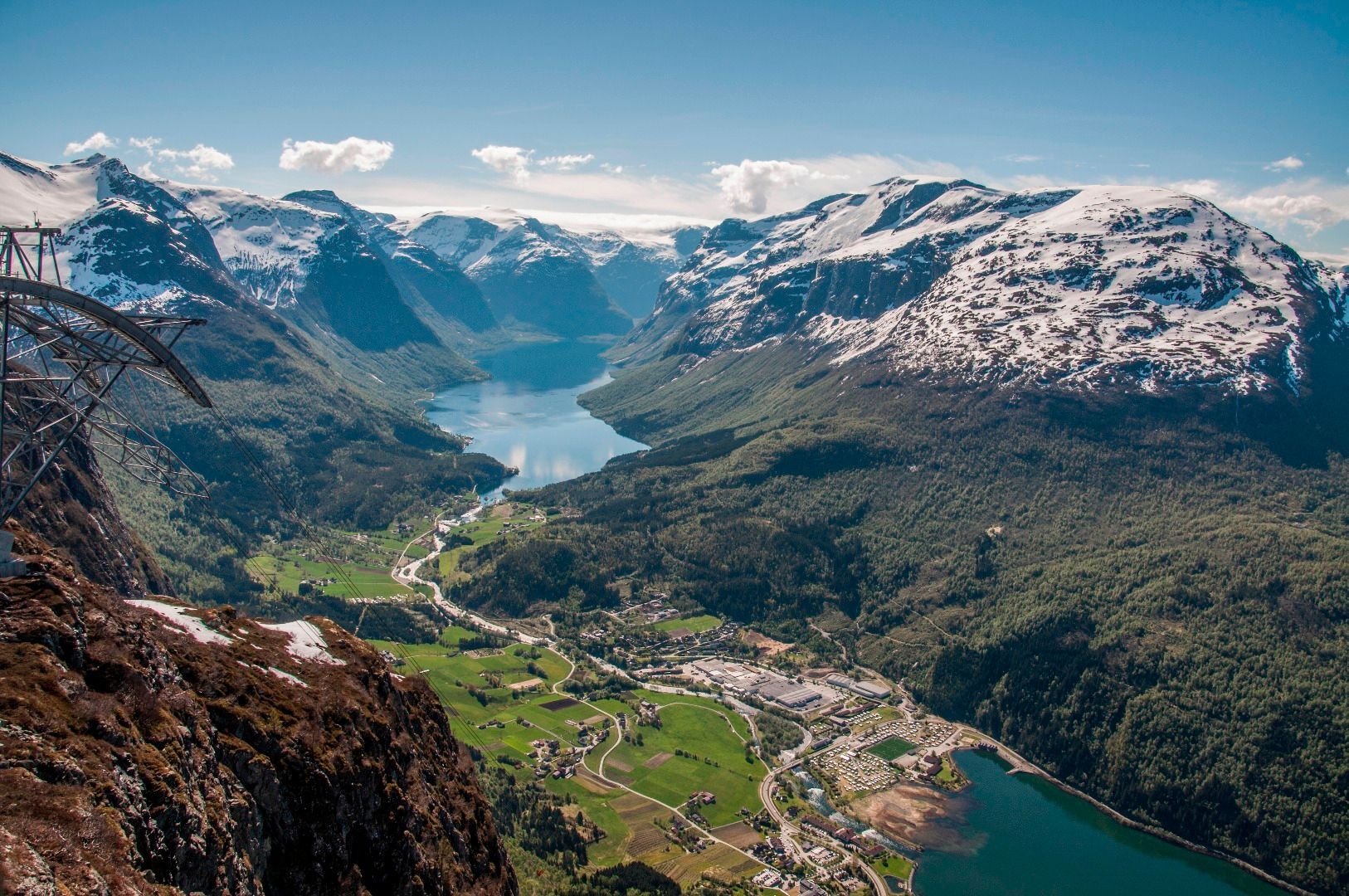 En luftfoto av en dal omgitt av fjell og en innsjø.