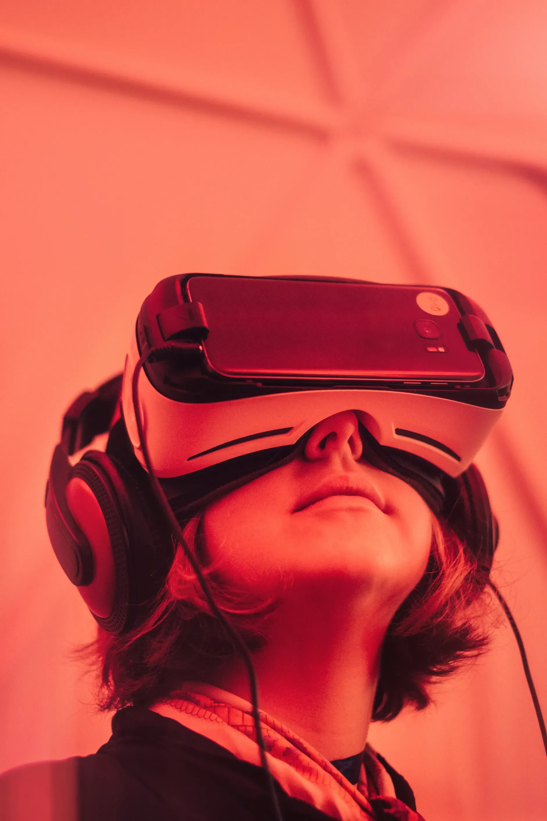 En kvinne har på seg et virtual reality-hodesett og hodetelefoner.