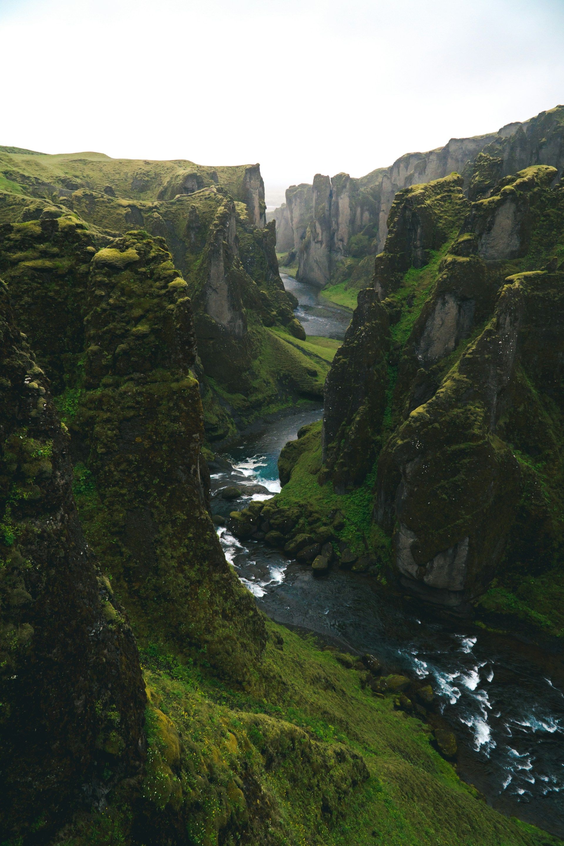 En elv renner gjennom en canyon mellom to fjell.