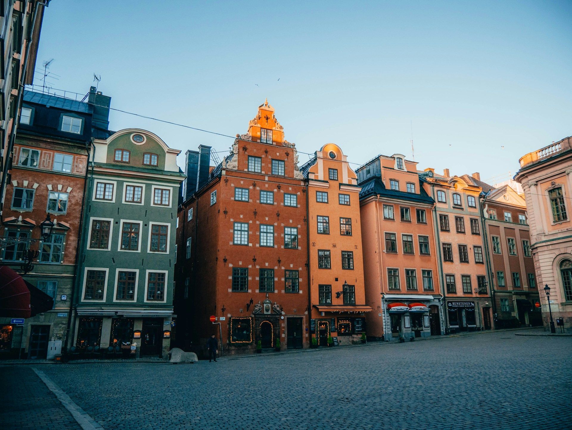En rad med bygninger står på rekke og rad på et torg i en by.