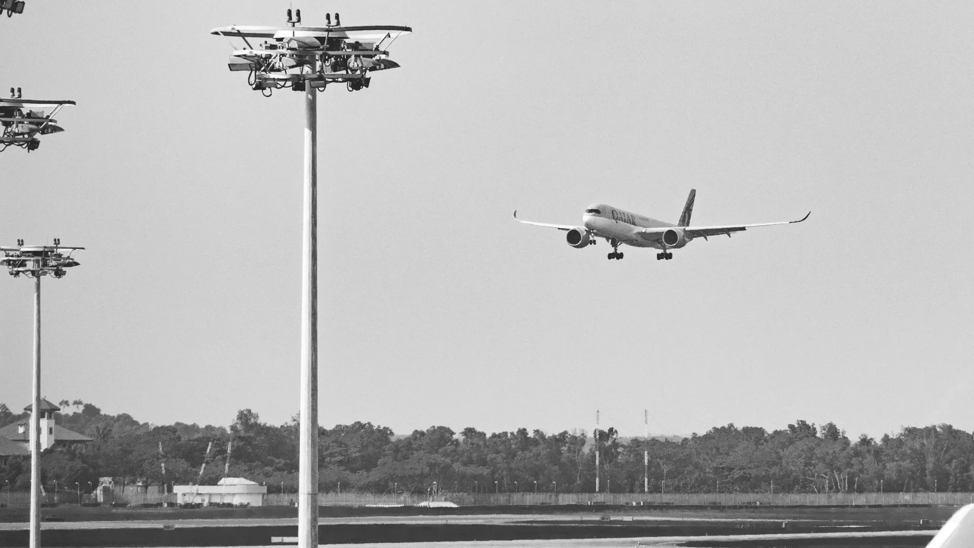 Et svart-hvitt-bilde av et fly som tar av fra en flyplass