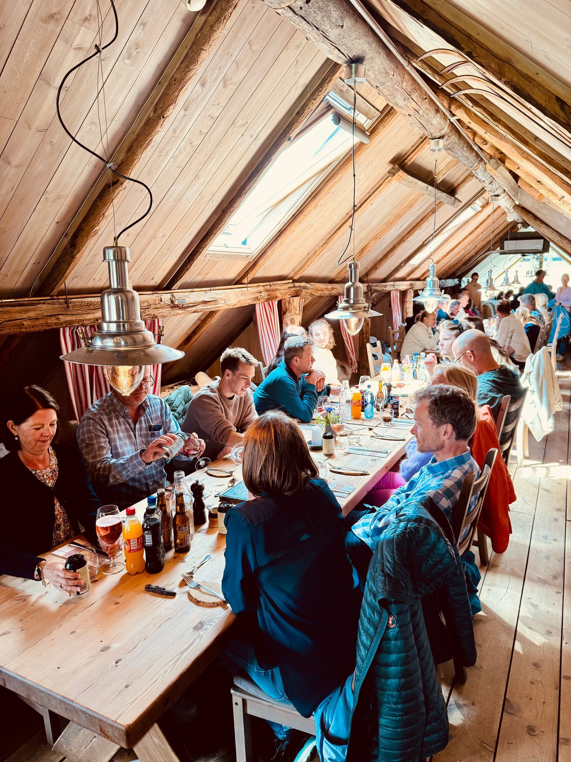 En gruppe mennesker sitter ved et langbord på en restaurant.