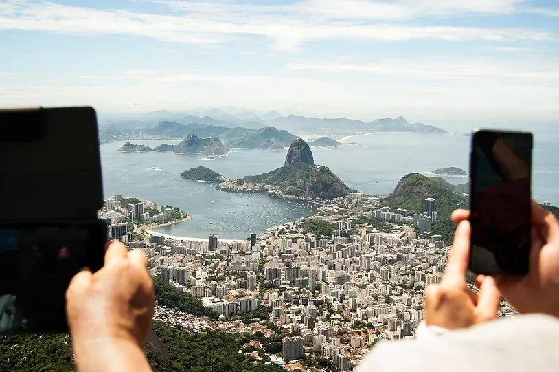 En person tar et bilde av en by med mobiltelefonen sin.