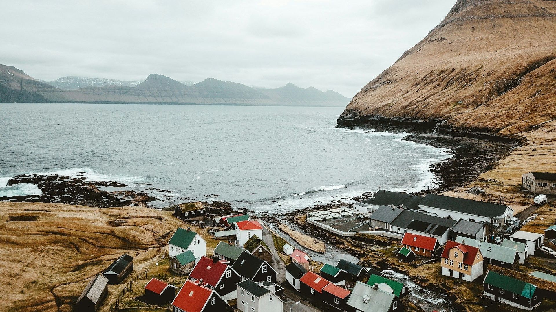 Et luftfoto av en liten landsby ved siden av en vannmasse.