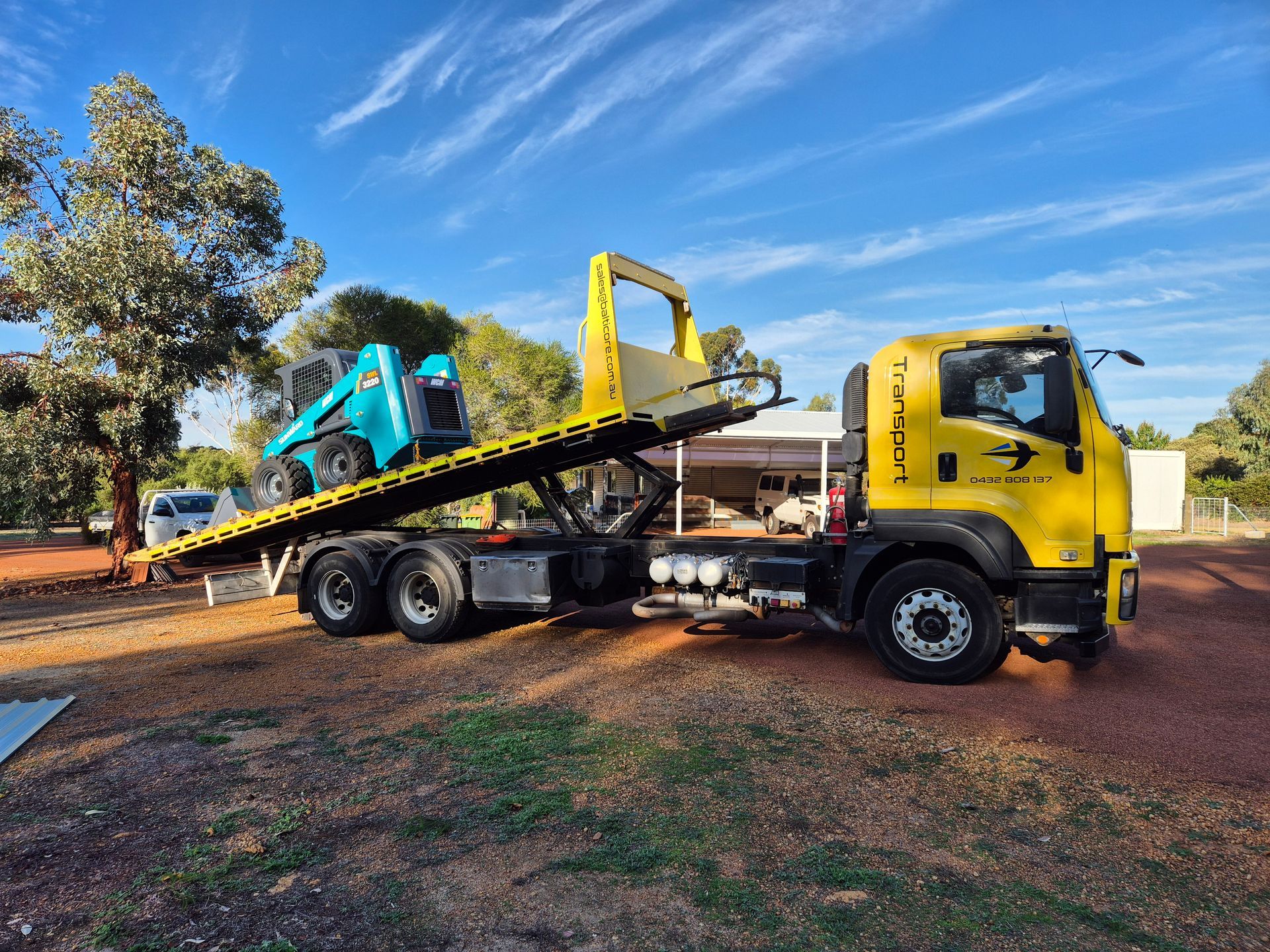 Balticore tilt tray loading a skid steer for machinery transport Perth WA