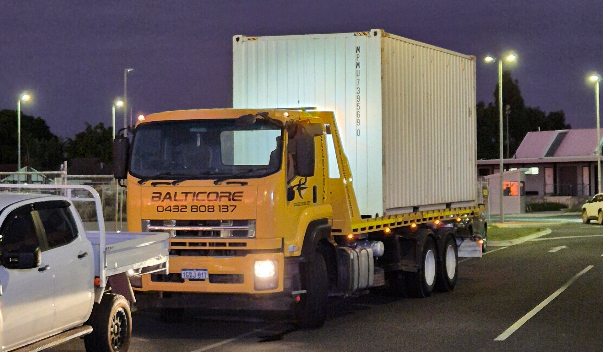 Worker in safety gear inspecting shipping containers.