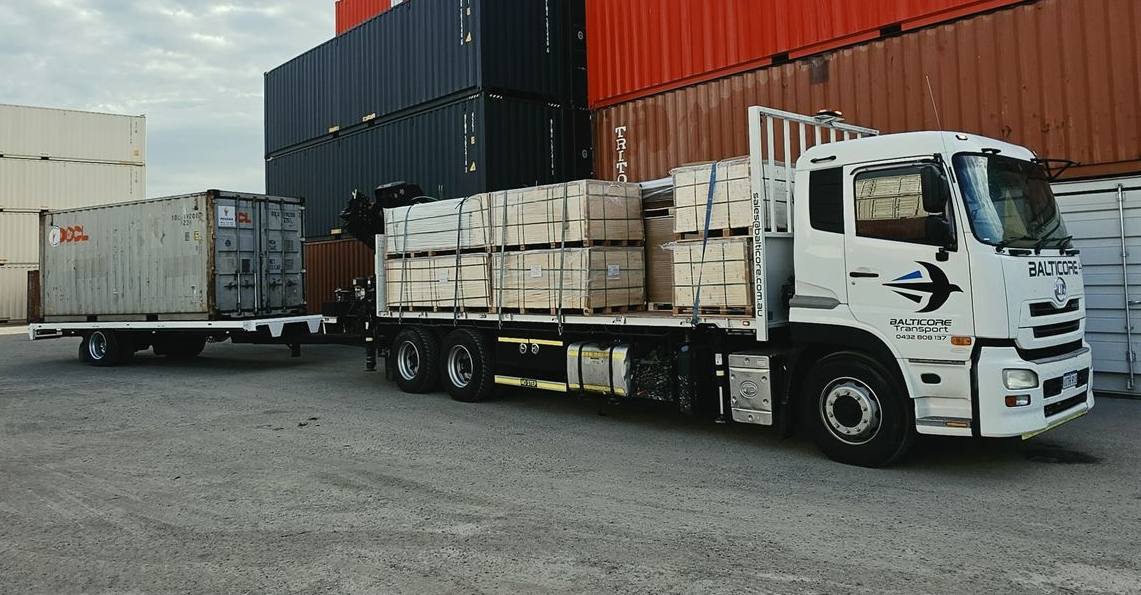 Balticore Hiab crane truck with palletised packs in a container yard