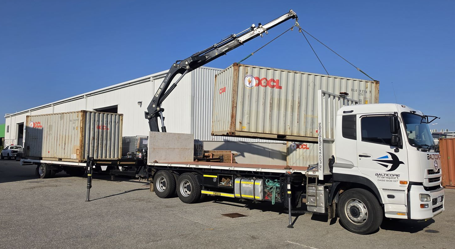 Balticore Hiab crane truck lifting a 20ft container in an industrial yard