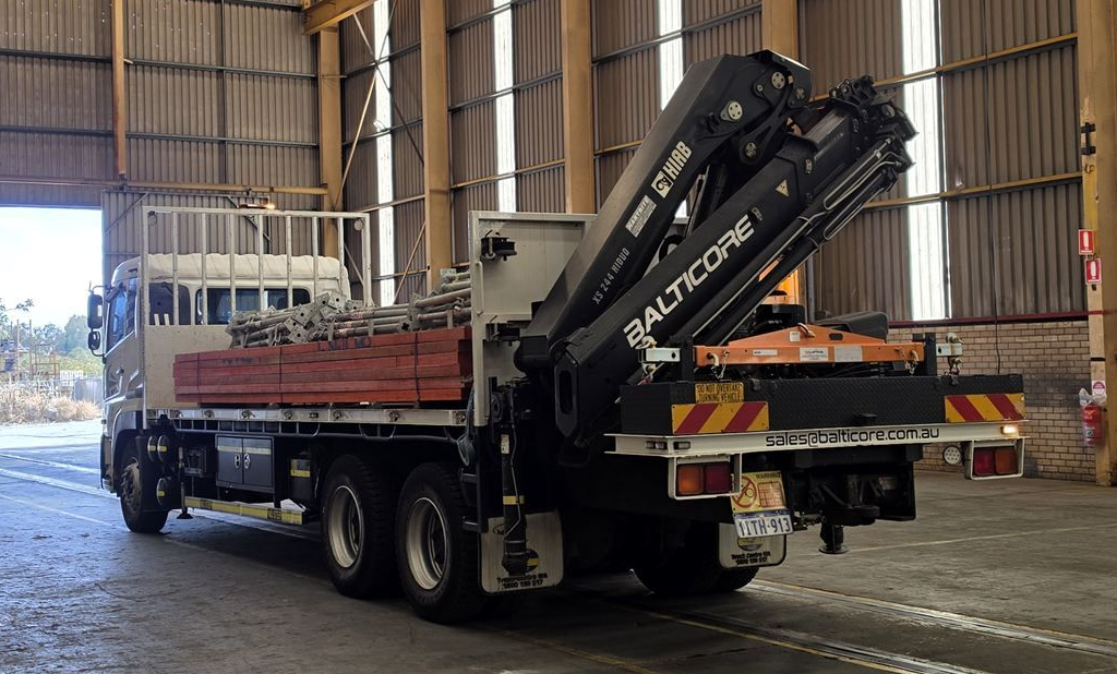 Balticore Hiab crane truck with a steel load inside an industrial workshop