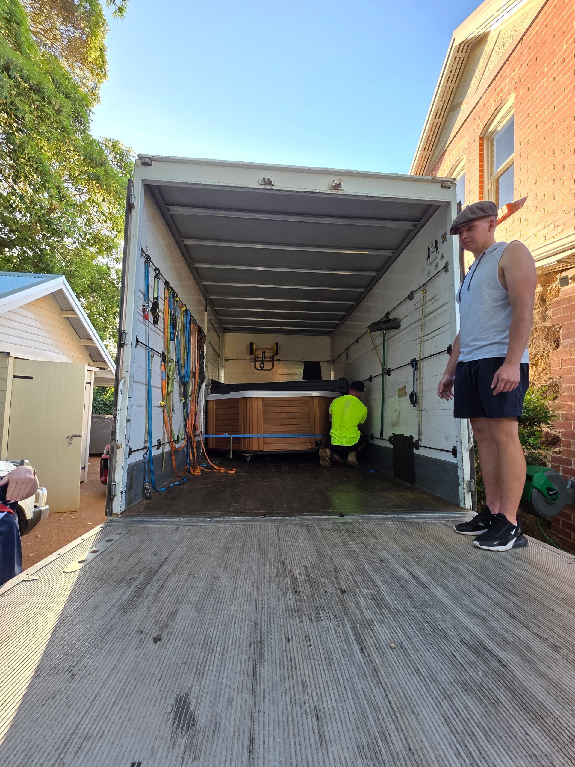 Wooden spa being loaded into an enclosed truck in Perth