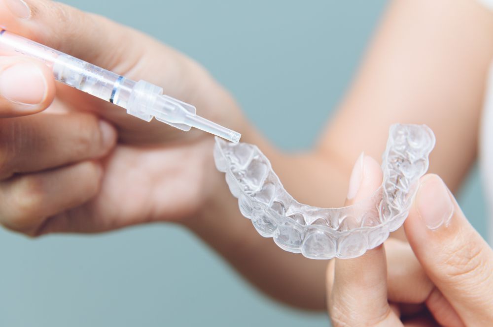 Person Applying a Clear Whitening Gel From a Syringe — Killara Dental in East Killara, NSW