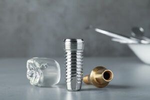 A Dental Implant, Abutment, and a Clear Model of a Tooth — Killara Dental in East Killara, NSW