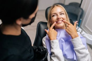 A Person in a Dental Chair Points to Their Teeth — Killara Dental in East Killara, NSW