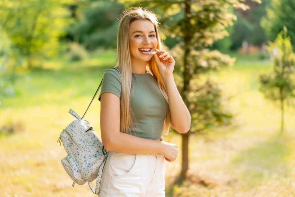 A Smiling Person With Braces Stands in a Park — Killara Dental in East Killara, NSW