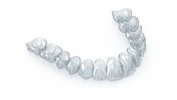 A Clear, Plastic Dental Aligner for the Lower Teeth Set Against a White Background — Killara Dental in East Killara, NSW
