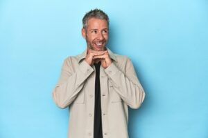 A Person With Short, Graying Hair Wears a Beige Overshirt and Black T-shirt — Killara Dental in East Killara, NSW