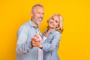 A Smiling Couple in Matching Denim Shirts Holding Hands — Killara Dental in East Killara, NSW