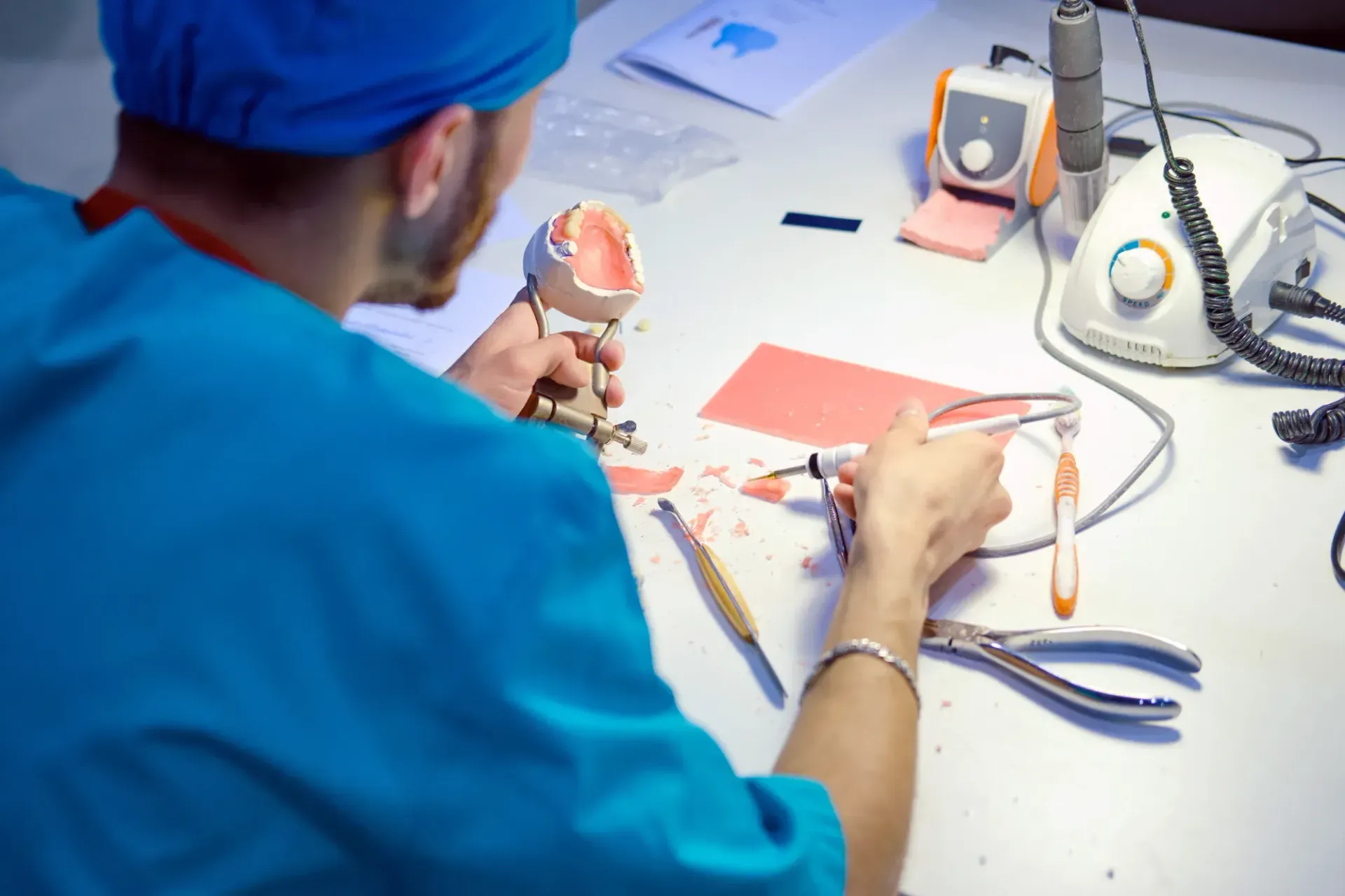 Person in Blue Cap Working With Dental Tools in a Clinical Workspace — Killara Dental I In Macquarie Park, NSW