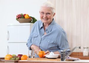 A Person Smiling While Cutting an Orange — Killara Dental in East Killara, NSW