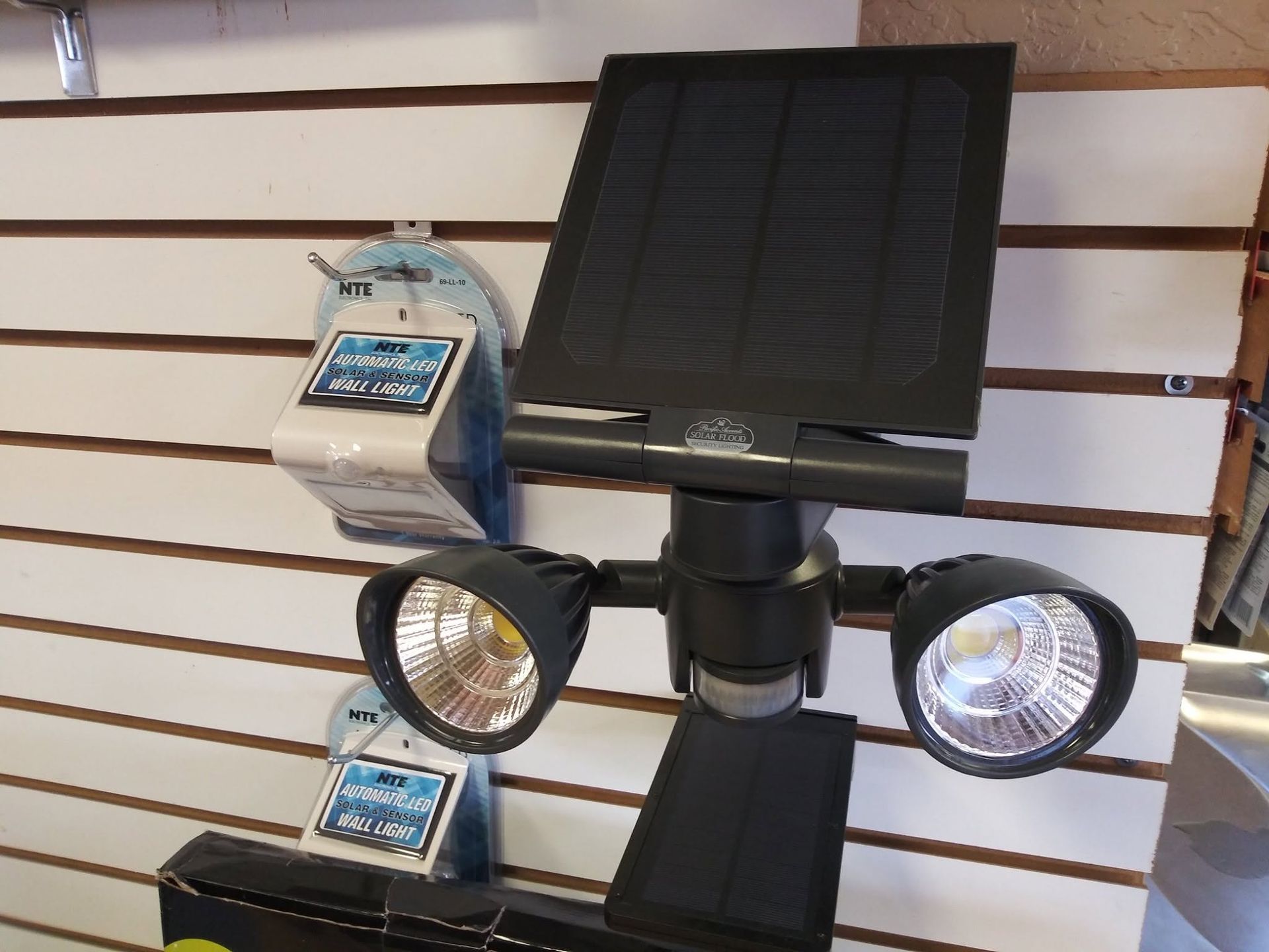 Solar-powered dual floodlight display on a store wall