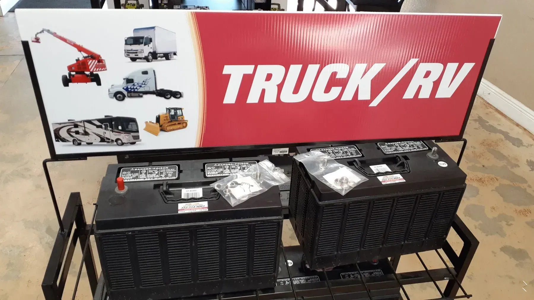 Truck/RV display sign behind two black metal storage boxes in a showroom.