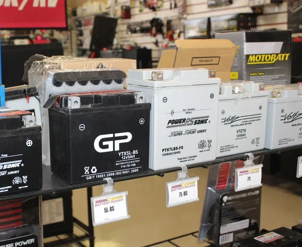 Battery packs displayed on store shelves, including black and white GP-branded units